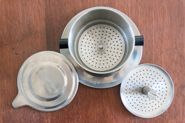How to Brew Vietnamese Iced Coffee June 9, 2014 by Michael Allen Smith  Vietnamese style iced coffee (ca phe sua da or cà phê sữa đá) is super easy to make and all you need is a stainless steel filter that costs around $7 USD online. If you live in a city with a Vietnamese grocery store, you will likely find them even cheaper.  Vietnamese coffee can be served hot, but for this tutorial we are going to brew an iced coffee that is both strong and sweet.  Although it is traditional to use dark roasted coffee for this drink, I discovered it is perfectly fine to use a medium roast. However, light roasted coffees should be avoid as they tend to be overpowered by the sweetness of the condensed milk.  What You’ll Need  Vietnamese Coffee Filter Ground coffee Sweetened Condensed Milk Spoon Glass or mug Ice Vietnamese Coffee Brewer  Vietnamese Coffee Filter Set